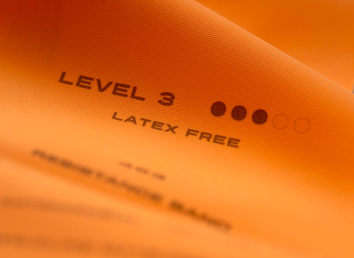Oranges Fitnessband mit Aufdruck Level 3 und Latex Free in der Nahaufnahme